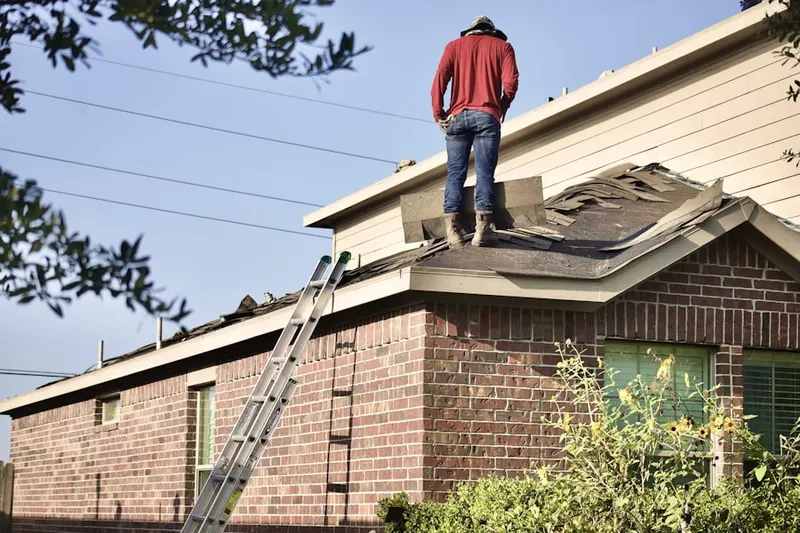 Professional roofer working on a residential roof in Dunlap